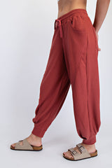 woman wearing brick red ribbed lounge pants with side pockets and elastic waistband