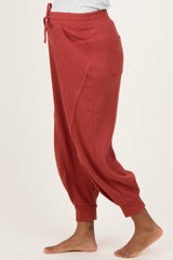 woman wearing a rust-colored ribbed maternity jogger pants with pockets and a relaxed fit