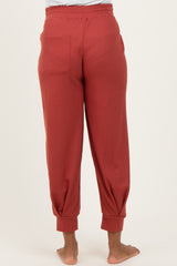 maternity wear rust-colored ribbed joggers with elastic waistband and cuffed ankles, model shown from the back