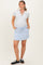 woman wearing a light gray maternity polo shirt and a light blue maternity skort with pockets