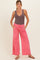 woman wearing a brown ribbed maternity tank top and coral pink wide-leg maternity pants with pockets