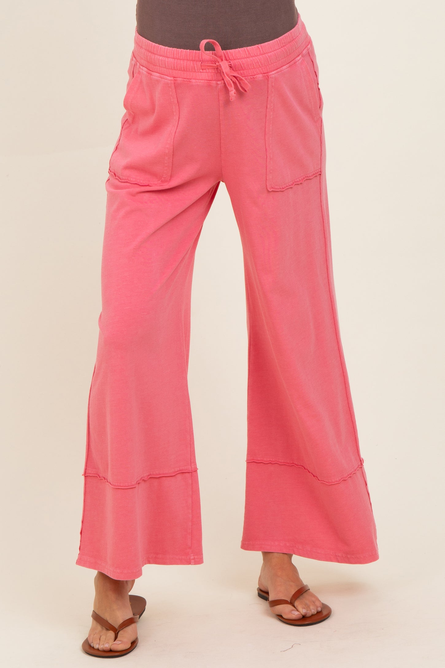 woman wearing light pink maternity lounge pants with a relaxed fit and pockets