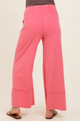 woman wearing pink maternity wide-leg pants, shown from the back, featuring a relaxed fit and comfortable waistband