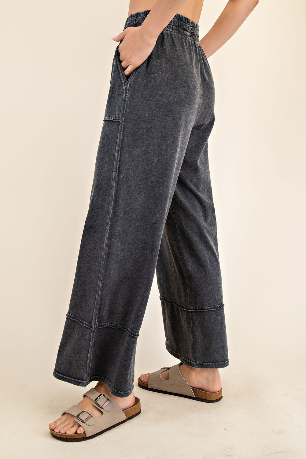 woman wearing dark gray wide-leg denim pants with an elastic waistband and side pockets