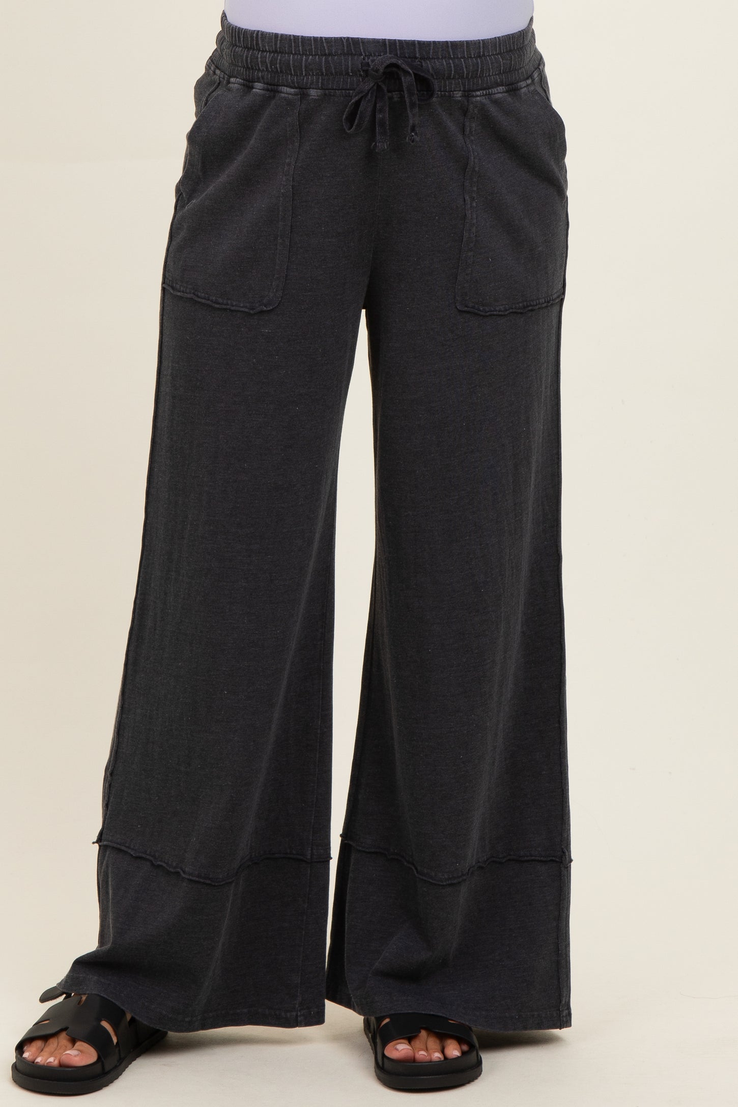 woman wearing dark gray maternity wide-leg pants with pockets and an elastic waistband