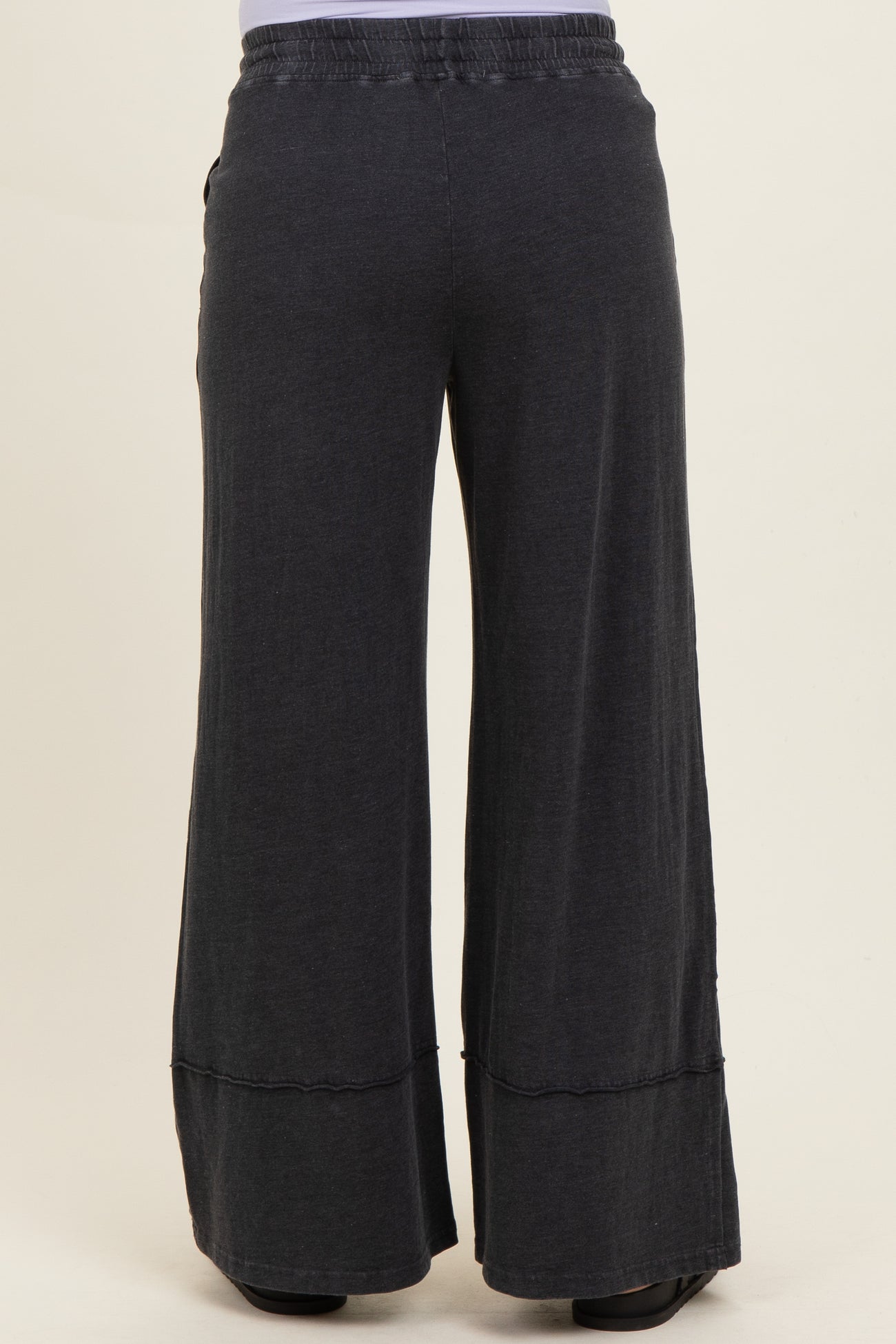 black wide-leg maternity pants with an elastic waistband and a relaxed fit, shown from the back