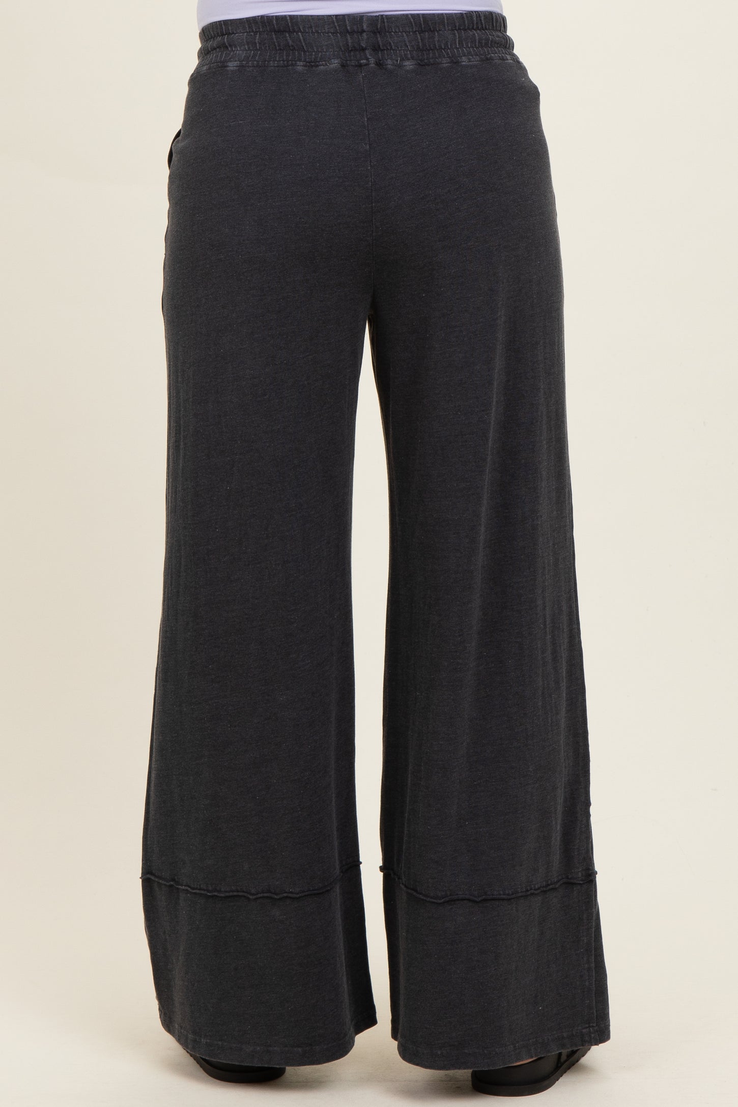 black wide-leg maternity pants with an elastic waistband and a relaxed fit, shown from the back