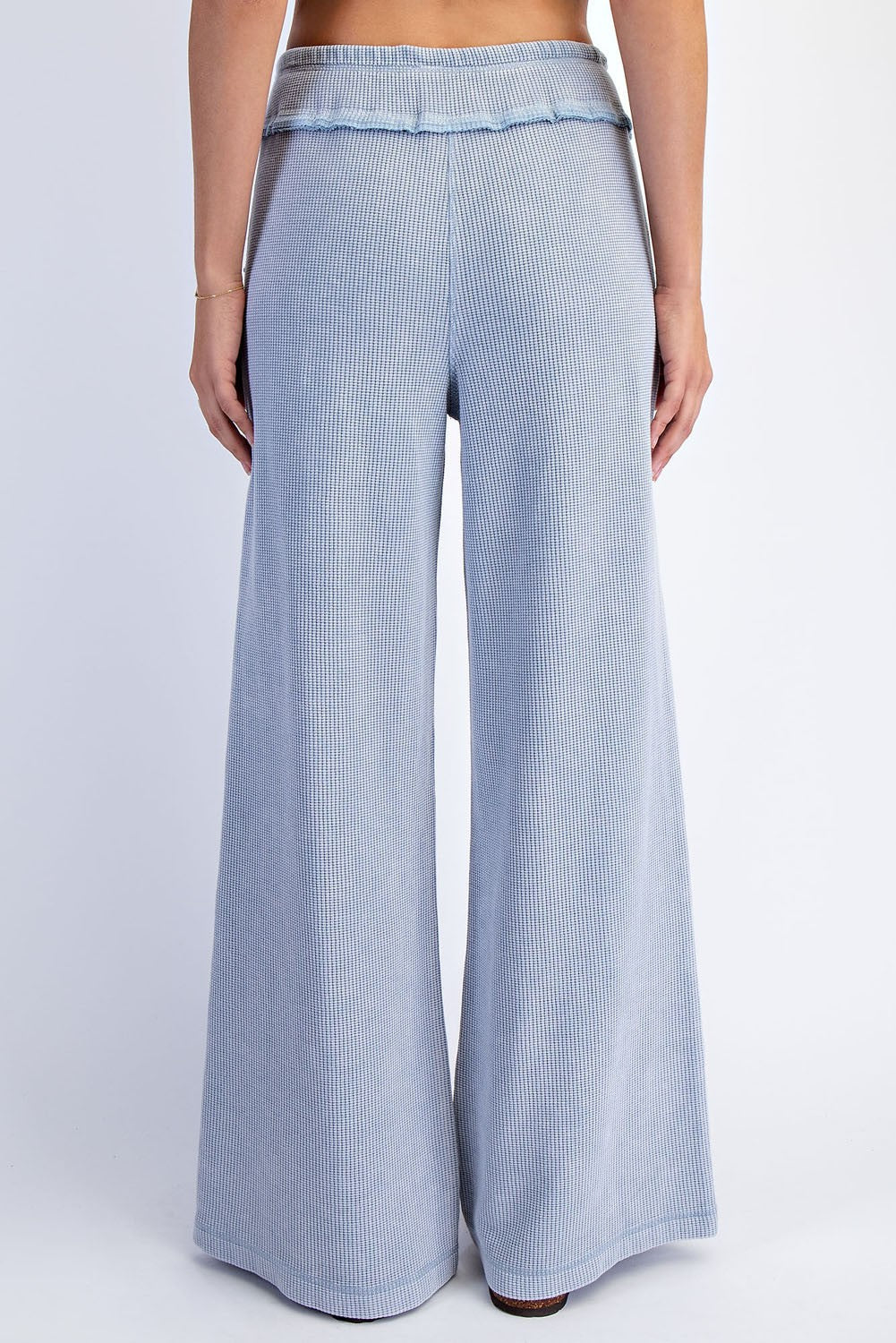 woman wearing light blue ribbed wide-leg pants, showing the back view with a flowy fit