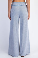 woman wearing light blue ribbed wide-leg pants, showing the back view with a flowy fit