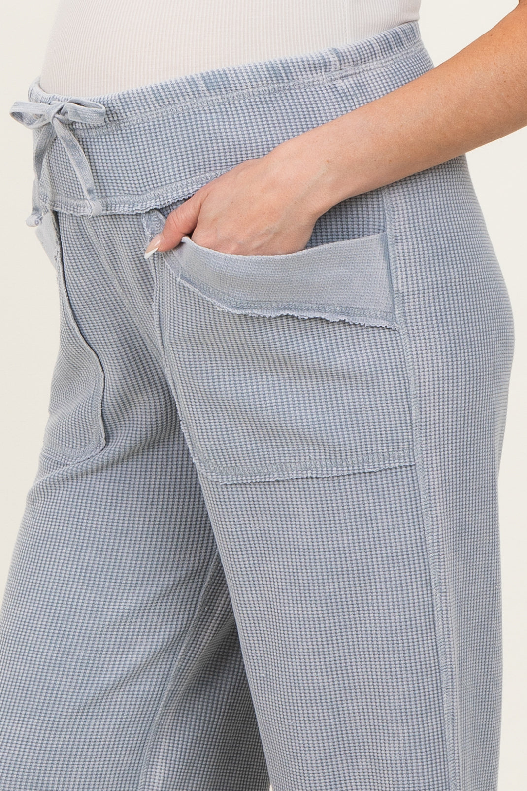 woman wearing blue and white checkered maternity pants with a drawstring waist and side pockets