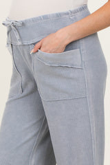 woman wearing blue and white checkered maternity pants with a drawstring waist and side pockets