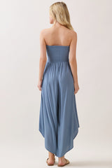 woman wearing a light blue strapless jumpsuit with a smocked bodice and flowy wide-leg pants