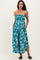 woman wearing a strapless teal floral maternity maxi dress with pockets and a fitted bodice, showcasing her baby bump