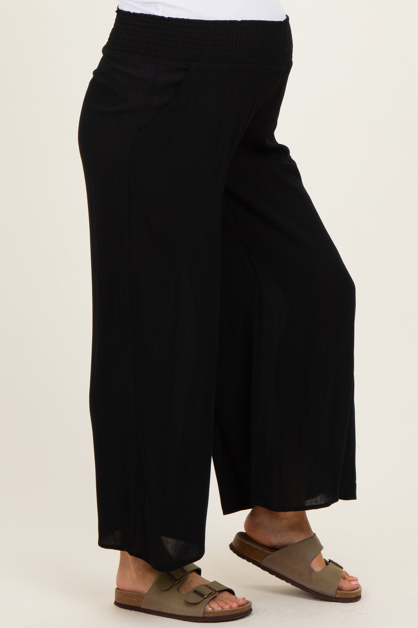 woman wearing black maternity wide-leg pants with a relaxed fit and an elastic waistband, showing a baby bump