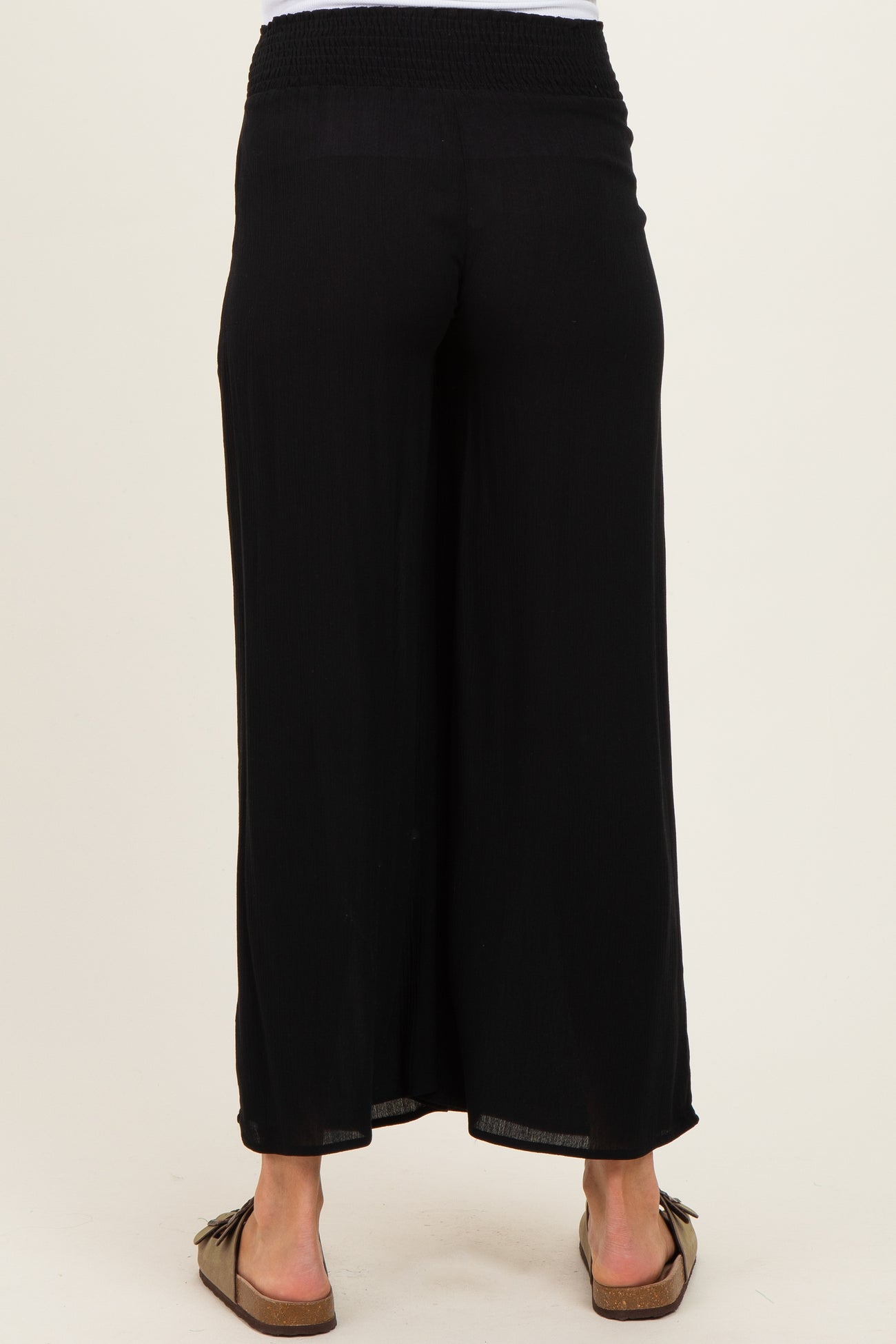 woman wearing black maternity wide-leg pants with a smocked waistband and a relaxed fit