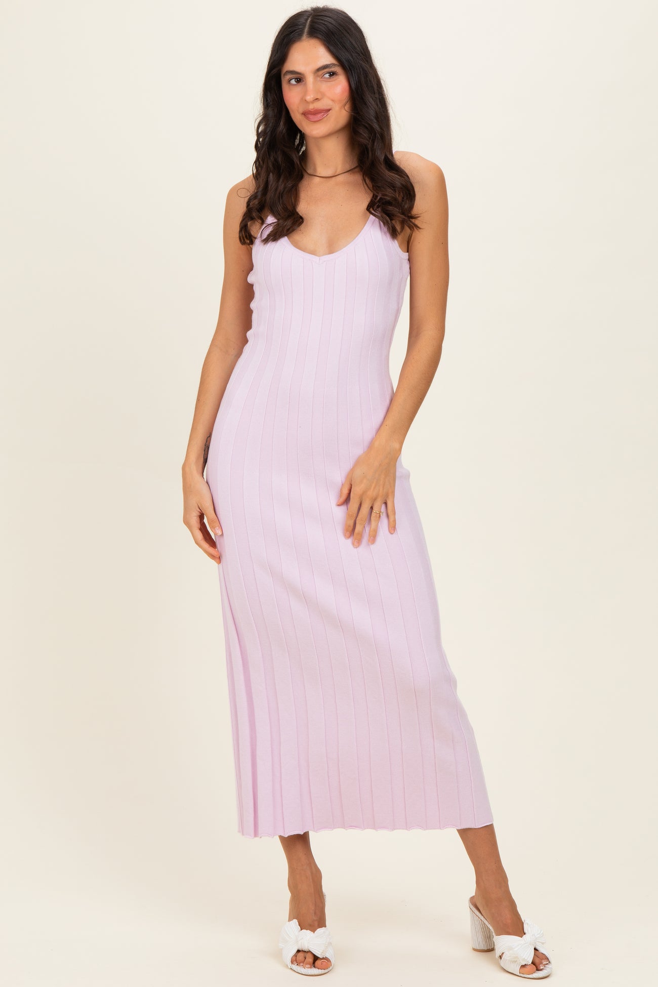 woman wearing a light purple ribbed midi dress with spaghetti straps and a fitted silhouette