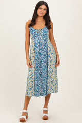 woman wearing a floral blue and yellow midi dress with a scoop neckline and adjustable straps
