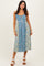 woman wearing a floral blue and yellow midi dress with a scoop neckline and adjustable straps