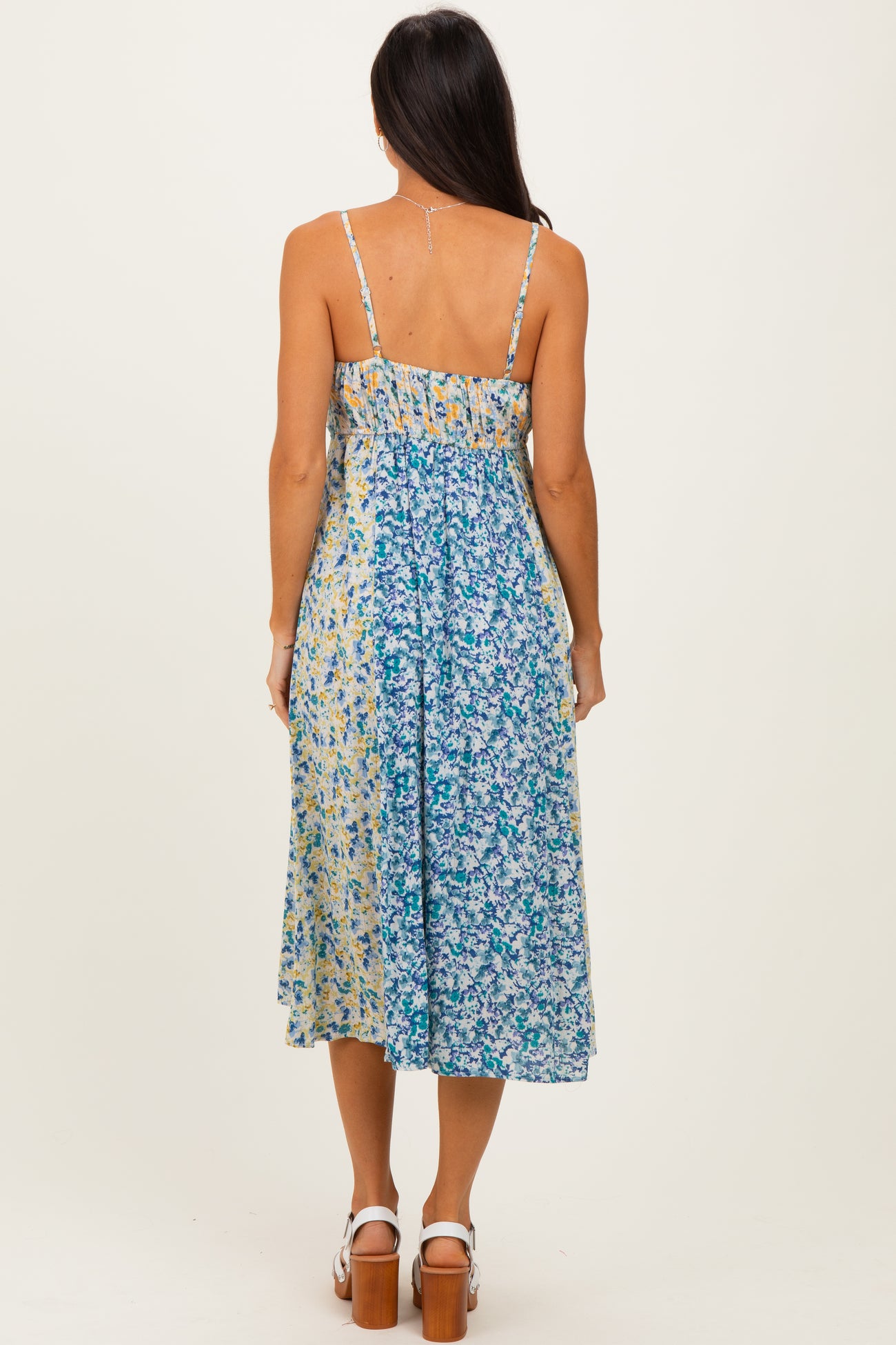 woman wearing a backless floral midi dress with adjustable straps and a smocked bodice