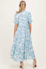 woman wearing a blue floral print maternity maxi dress with short sleeves and a flowy skirt