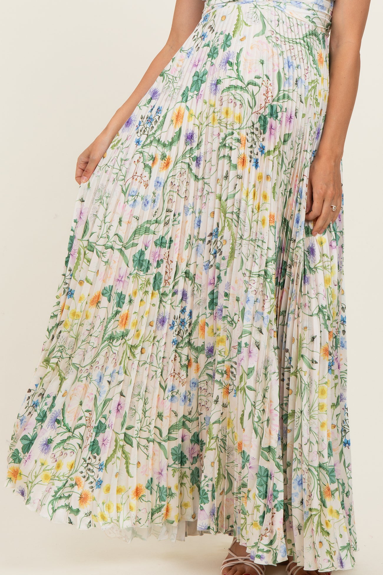 woman wearing a flowy floral pleated maternity maxi skirt with colorful patterns and a comfortable fit