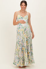 woman wearing a floral print maternity maxi dress with a fitted bodice and pleated skirt, showing her baby bump