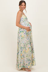 woman wearing a floral maxi maternity dress with pleats and holding her baby bump