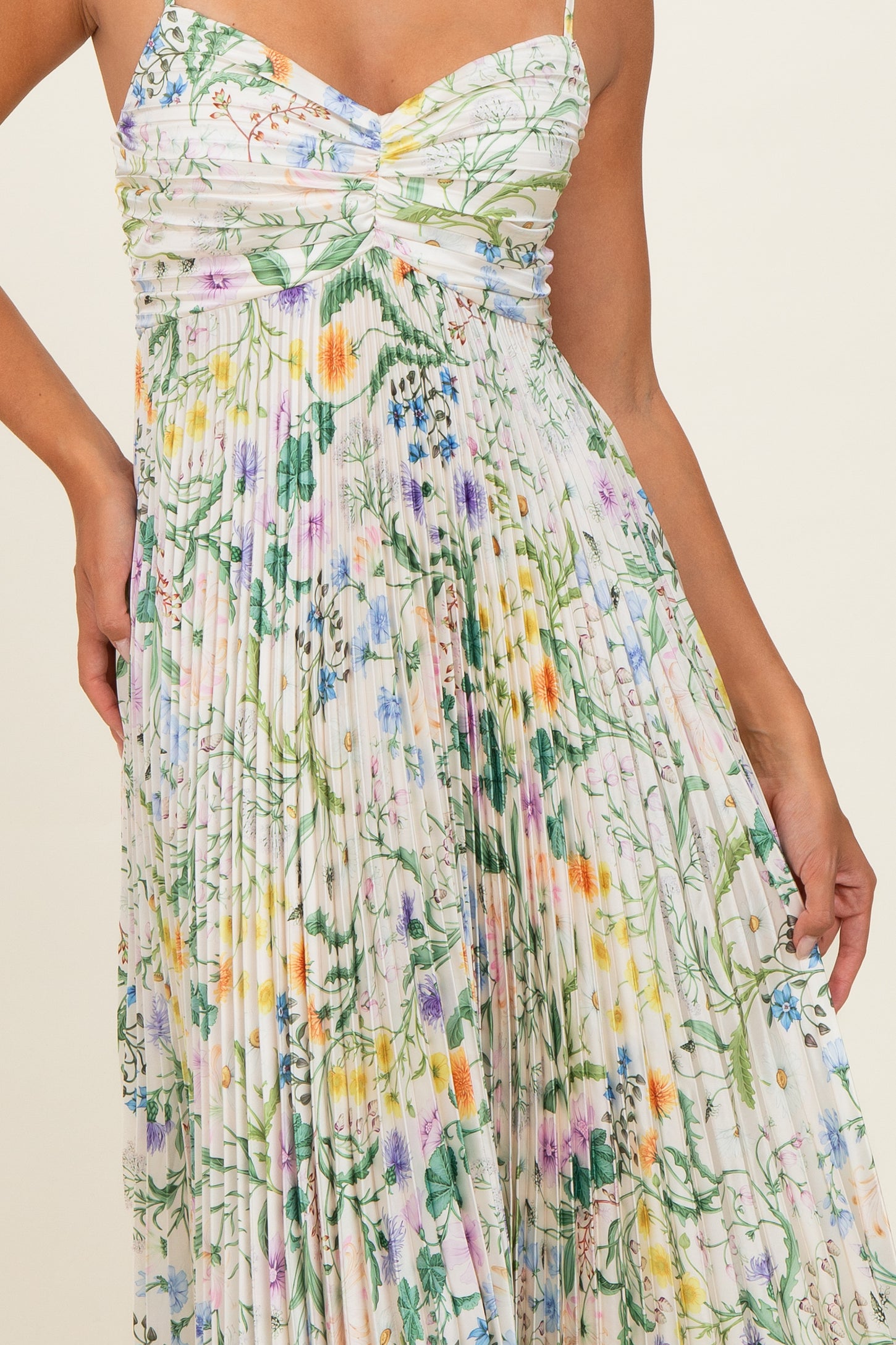 woman wearing a floral print pleated maxi dress with a sweetheart neckline and spaghetti straps