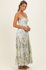 woman wearing a floral maxi dress with spaghetti straps and pleated detailing, styled with a hair accessory