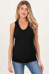 woman wearing a black sleeveless maternity top with a v-neck and a visible baby bump