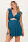 woman wearing a teal maternity dress with ruffle sleeves and a cutout detail, showing her baby bump