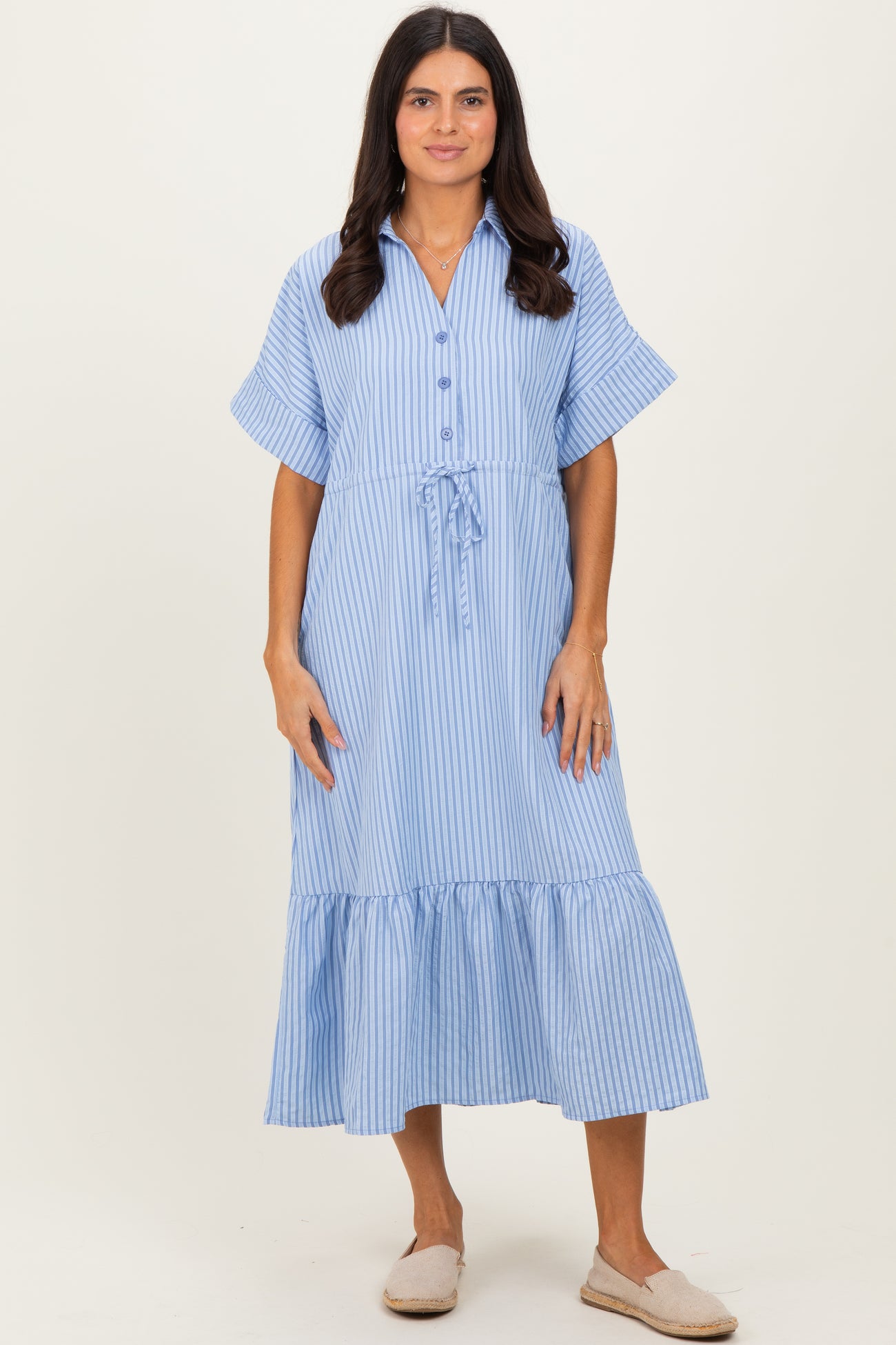 woman wearing a blue and white striped midi dress with short sleeves and a drawstring waist.