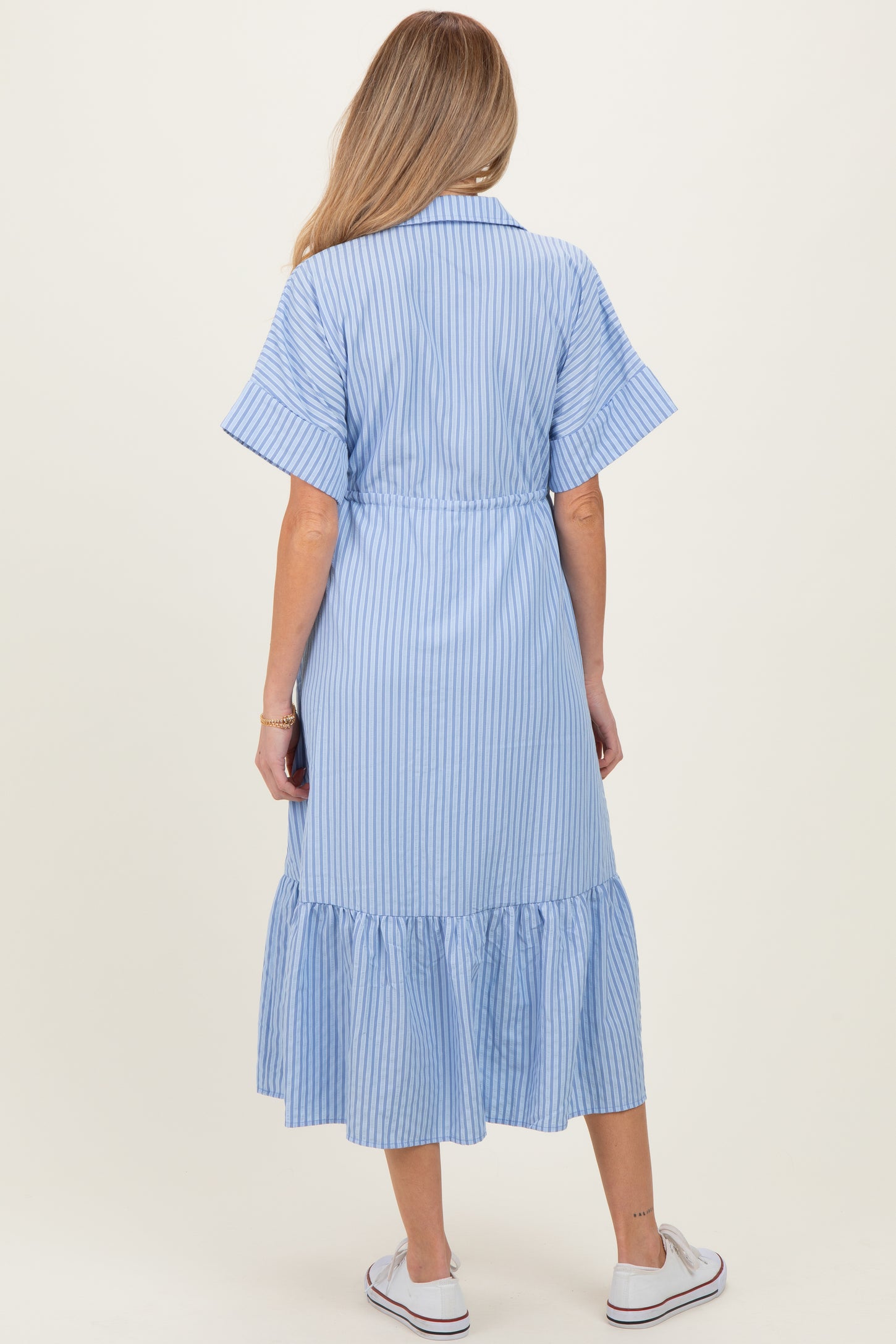 woman wearing a blue and white striped maternity dress with short sleeves and a flounce hem