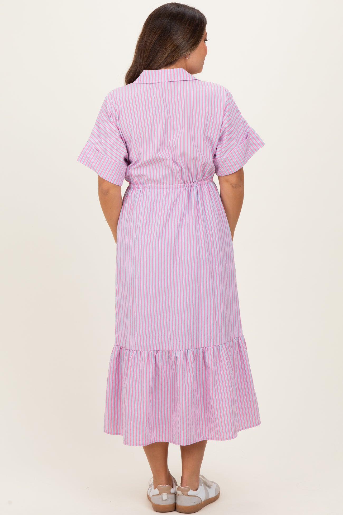 woman wearing a pink and white striped maternity dress with short sleeves and a ruffled hem