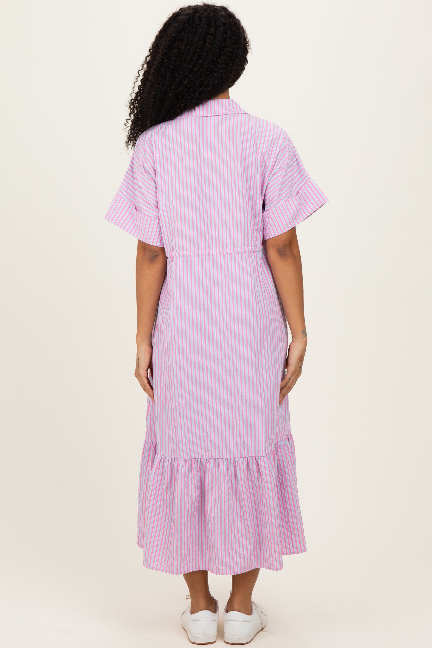 woman wearing a lilac and white striped midi dress with short sleeves and a ruffled hem