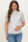 woman wearing a white floral short sleeve maternity top and holding her baby bump