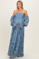 woman wearing a light blue off-the-shoulder lace maxi dress with bell sleeves and holding her baby bump