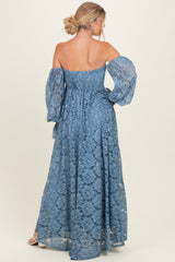 woman wearing a blue off-the-shoulder maxi dress with lace detailing and puff sleeves, shown from the back