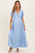 woman wearing a light blue maxi dress with puff sleeves and a deep v-neck, showing her baby bump