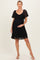 woman wearing a black lace maternity dress with short sleeves and a fitted empire waist, holding her baby bump