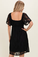 woman wearing a black lace short sleeve dress with a square back and a fitted waist