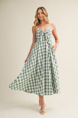 woman wearing a green and white gingham maxi dress with a tie front and pockets