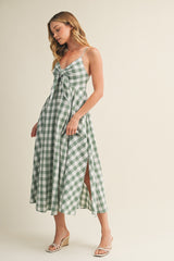 woman wearing a green and white gingham midi dress with a tie front and side slit