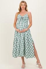 woman wearing a green and white gingham maternity dress with a tie front and side slits, showing her baby bump