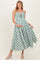 woman wearing a green and white gingham maternity dress with a tie front and buttons, showing her baby bump