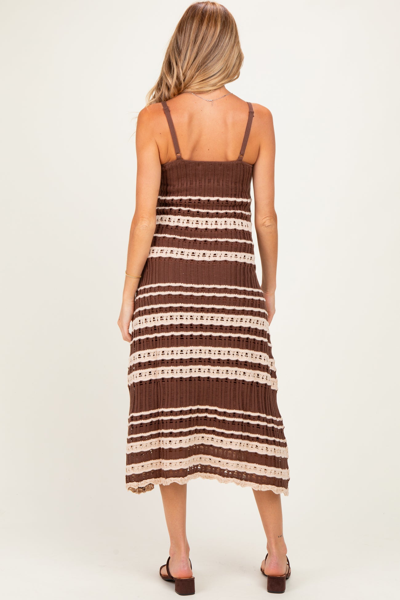 woman wearing a brown and beige striped maternity dress with adjustable spaghetti straps