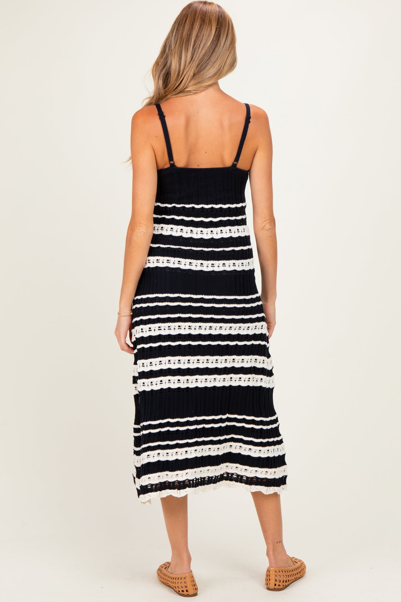 woman wearing a black and white striped maternity dress with a tiered design, showing her back