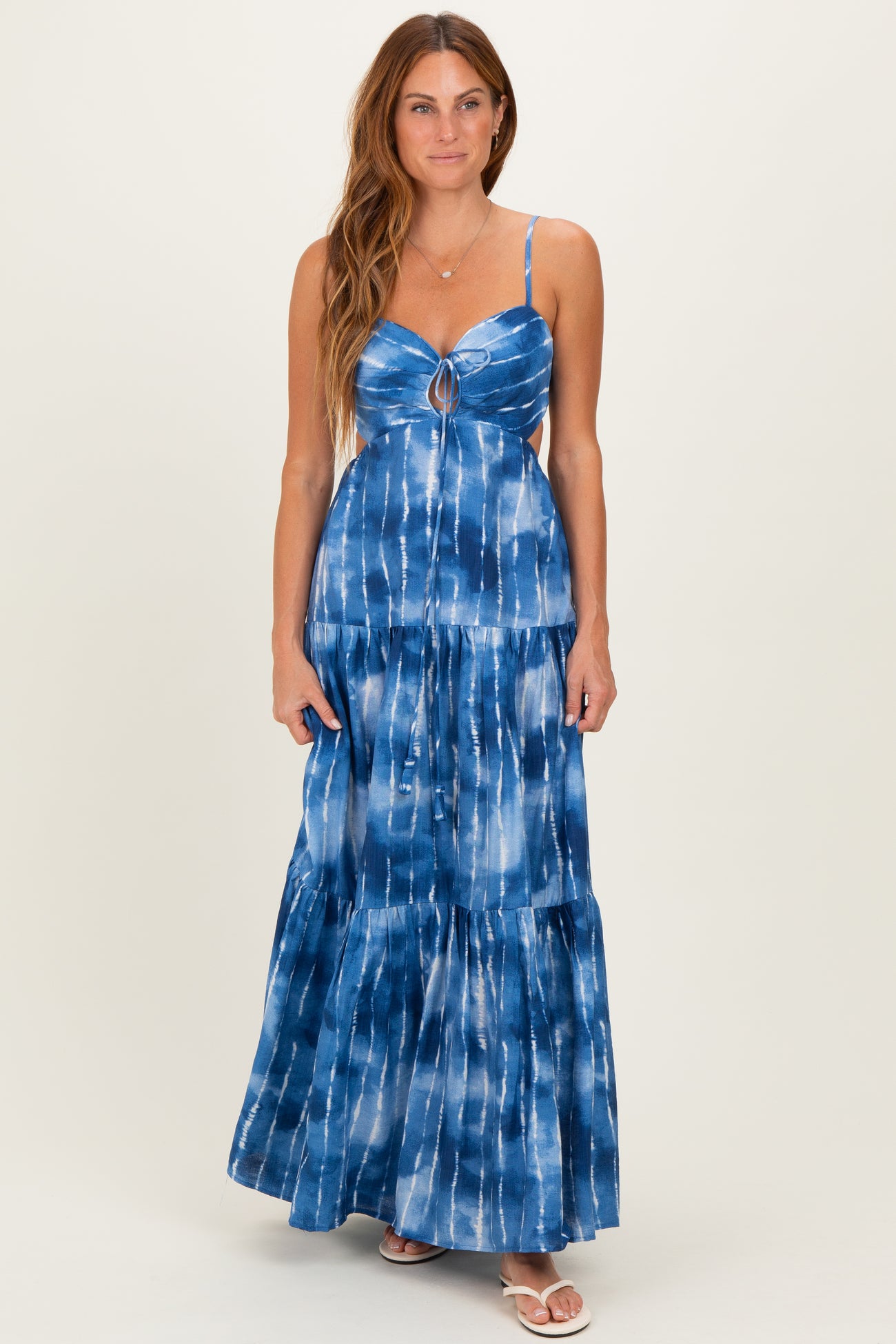 woman wearing a blue tie-dye maxi dress with a keyhole detail and tiered ruffles