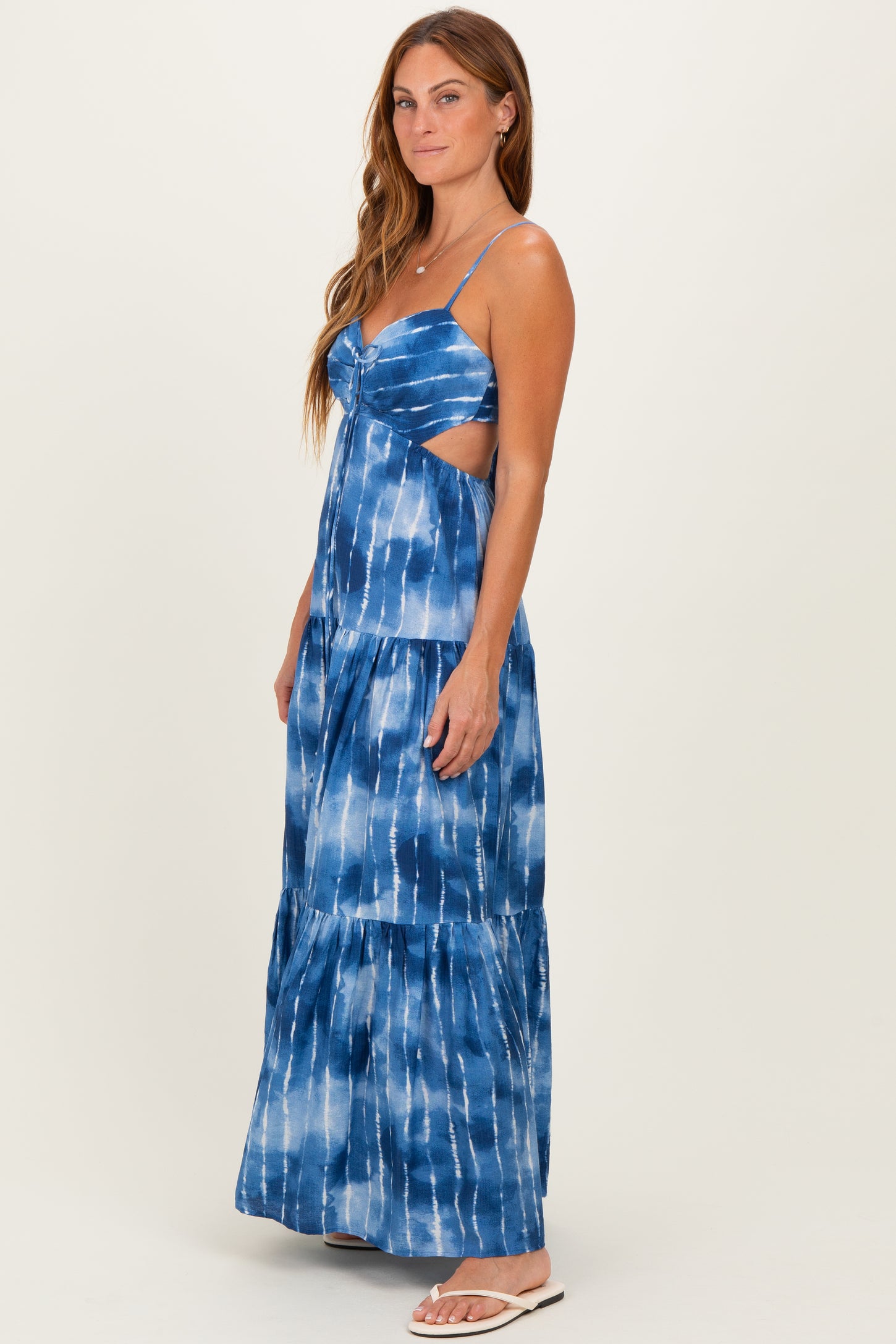 woman wearing a blue tie-dye maxi dress with spaghetti straps and cut-out details