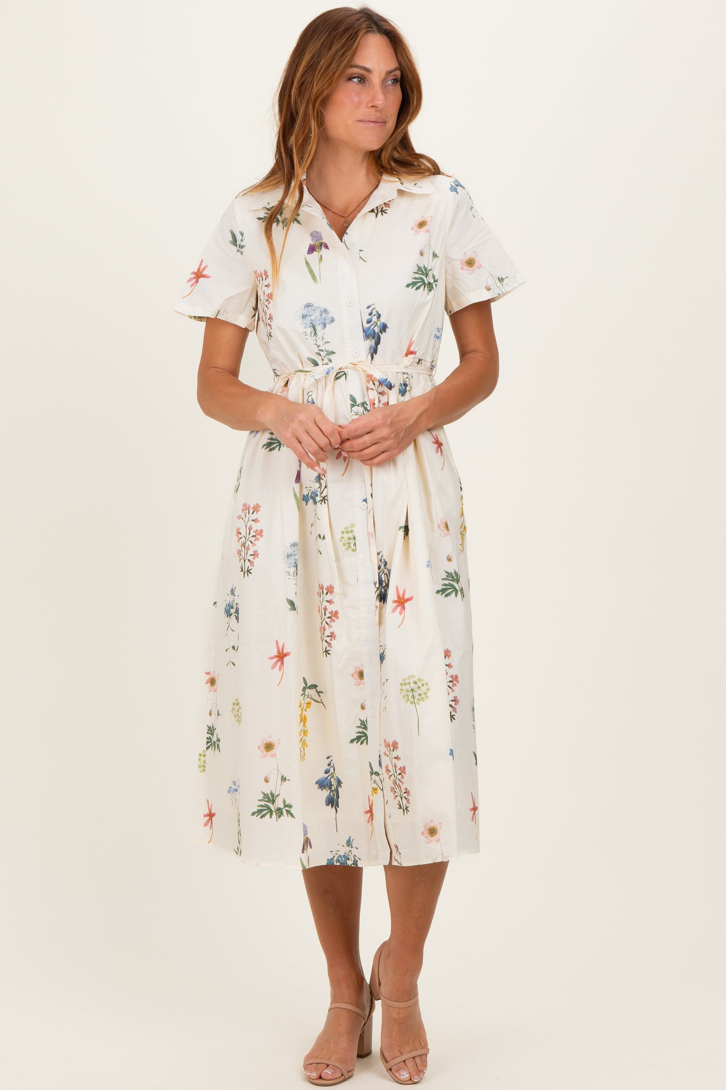 woman wearing a floral midi dress with short sleeves and a tie waist detail